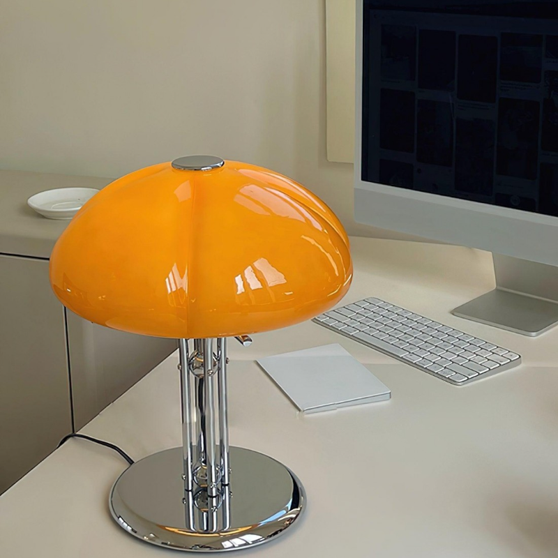 Orange Hector lamp on a desk near a computer