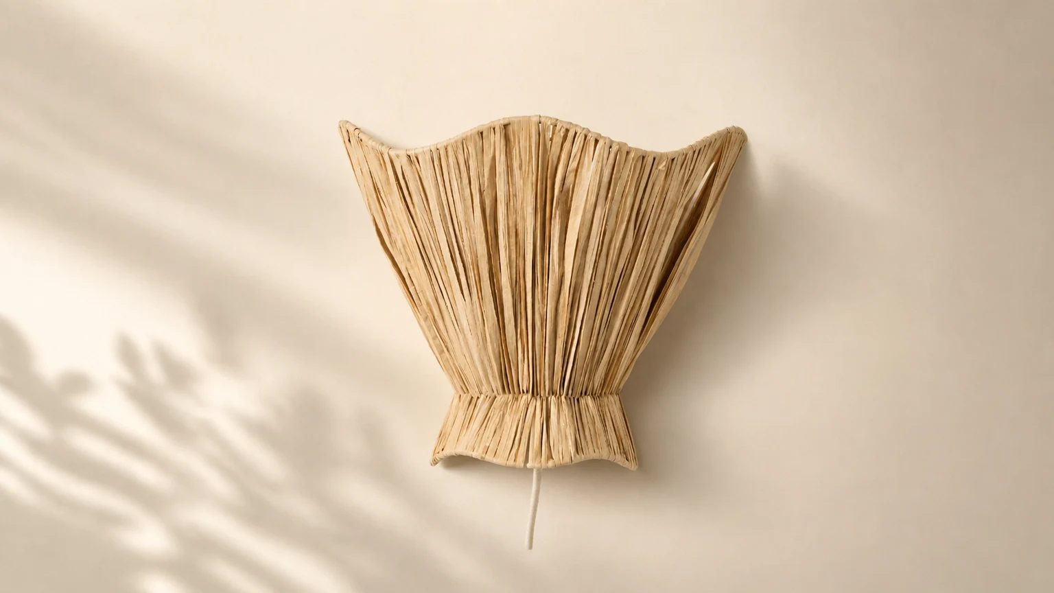 Ellara raffia scalloped wall light in a warm room setting