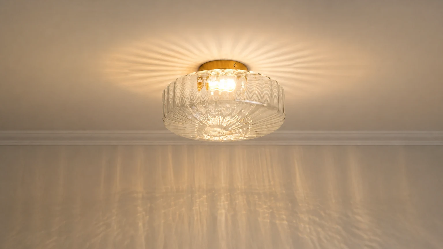 Plafon circular de latão com nervuras de vidro Calliope instalado em um interior aconchegante