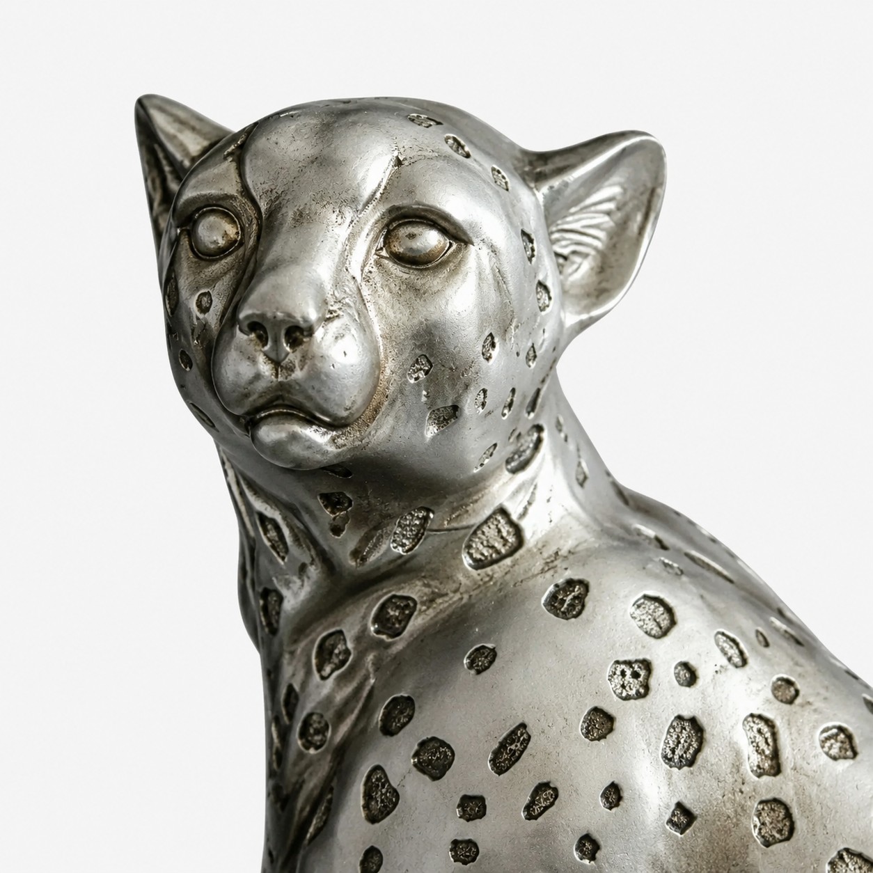 Primer plano de la escultura de leopardo, cara, orejas y detalle de la superficie