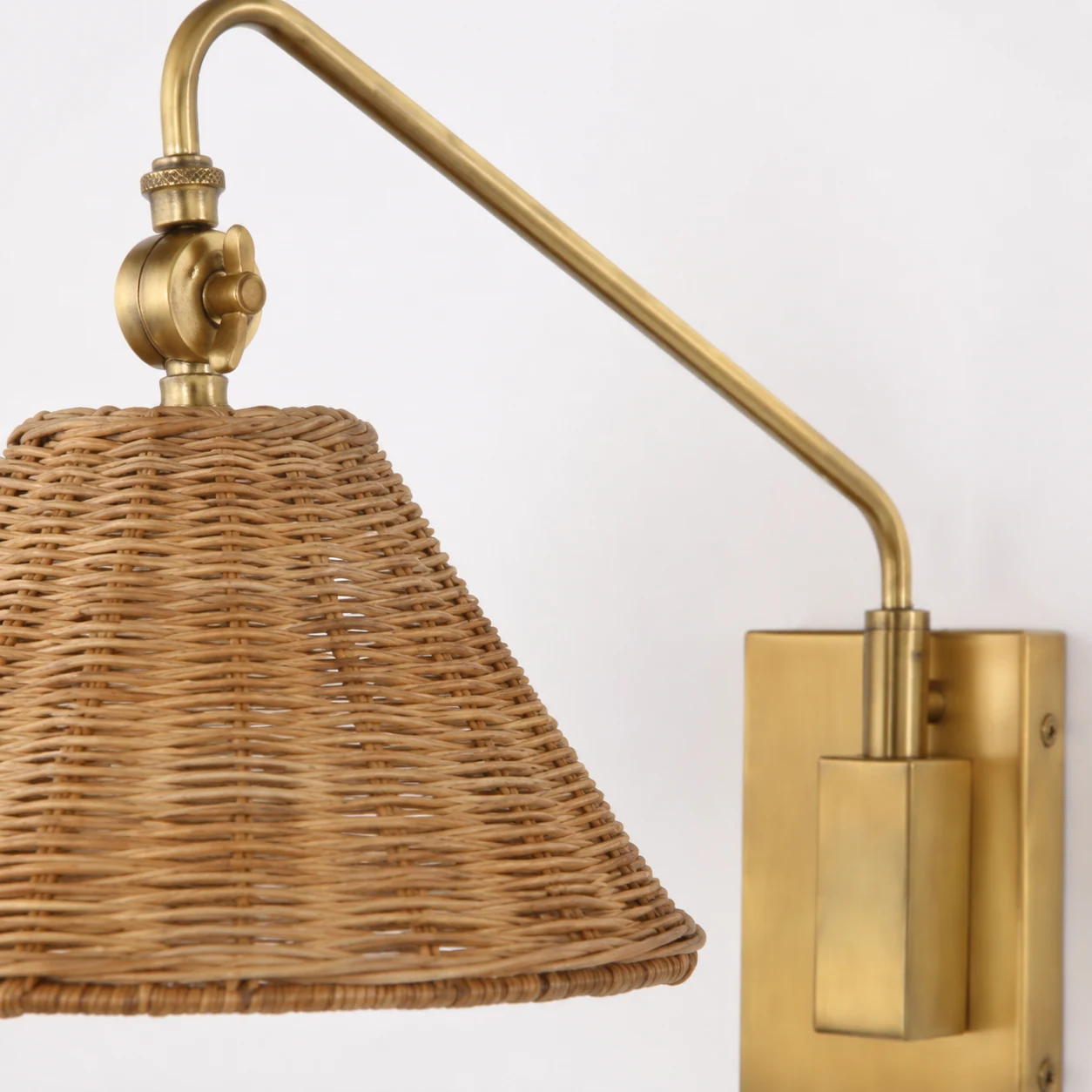 Close-up detail of the Mazan brass and rattan wall sconce materials