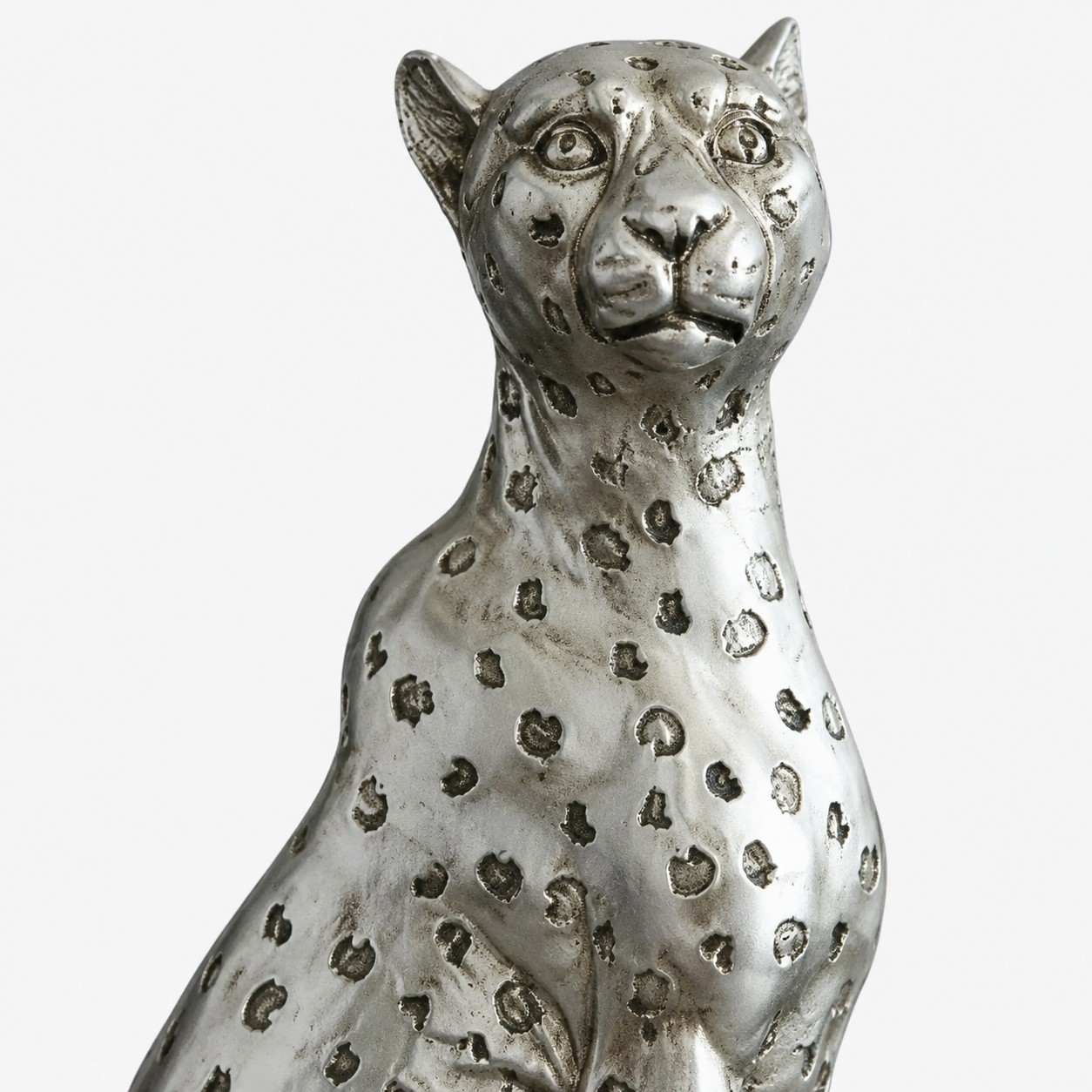 Primer plano del torso de escultura de leopardo de resina plateada y acabado manchado