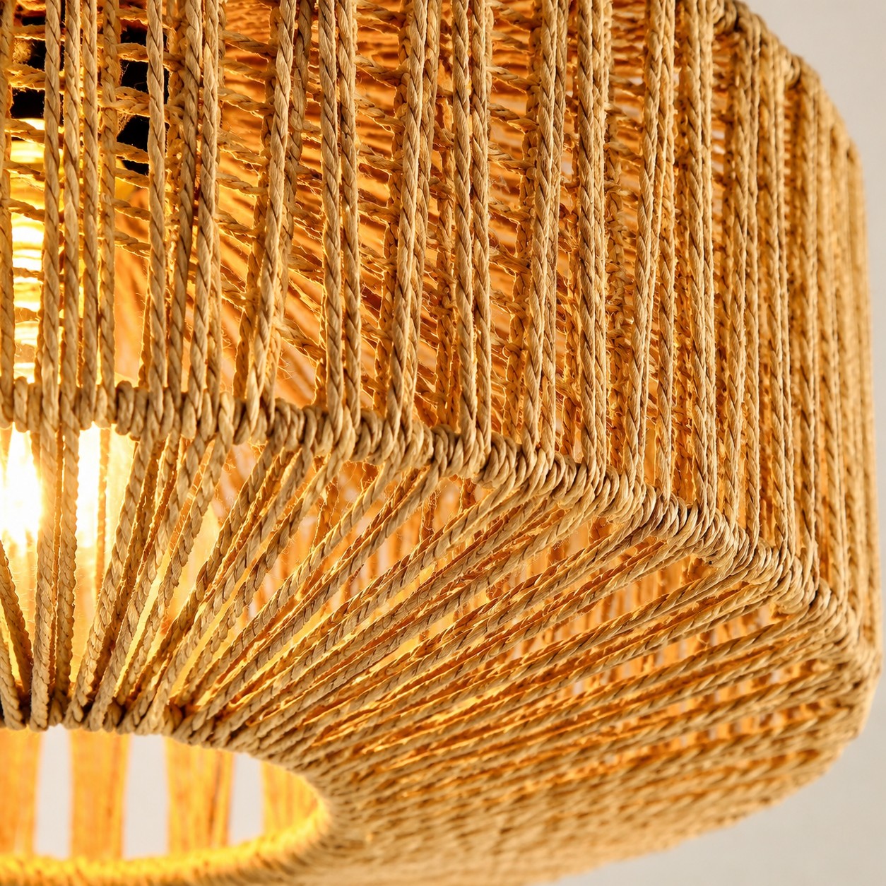 Illuminated close-up of the Balriel woven rattan shade and lower rim