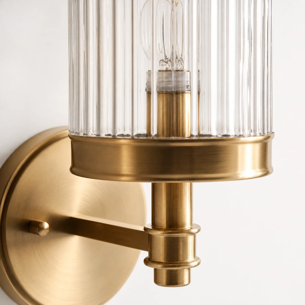 Close-up detail of ribbed glass shade and metal hardware on the Hebb wall sconce