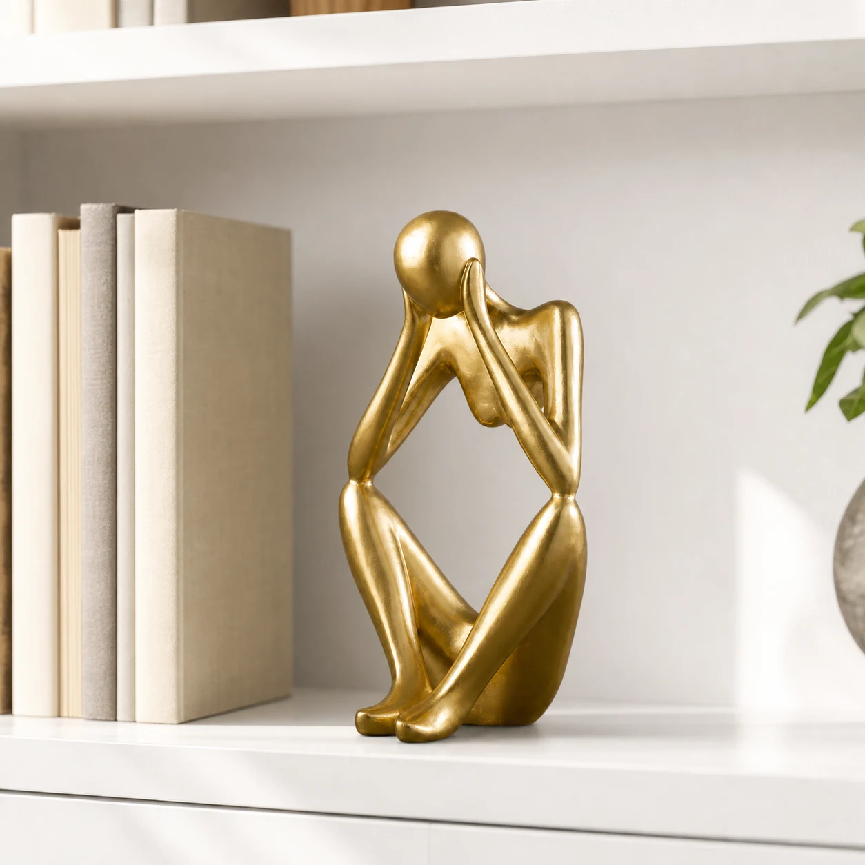 Gold abstract thinker sculpture styled in a refined interior