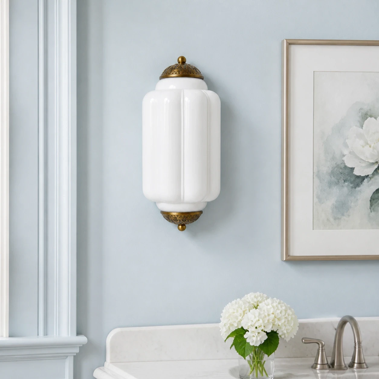 Aplique de pared de cristal blanco y latón en el aseo.