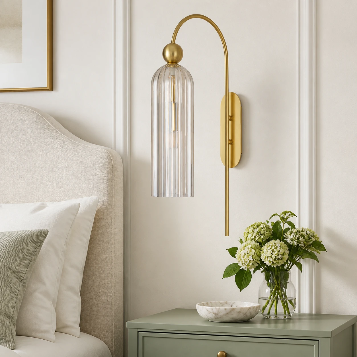 Clear glass Azura wall sconce beside a bed