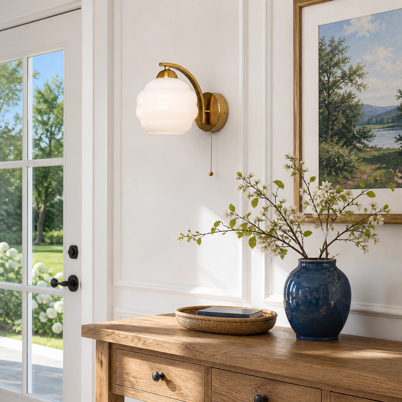 White milk glass sconce above a sunlit entry console