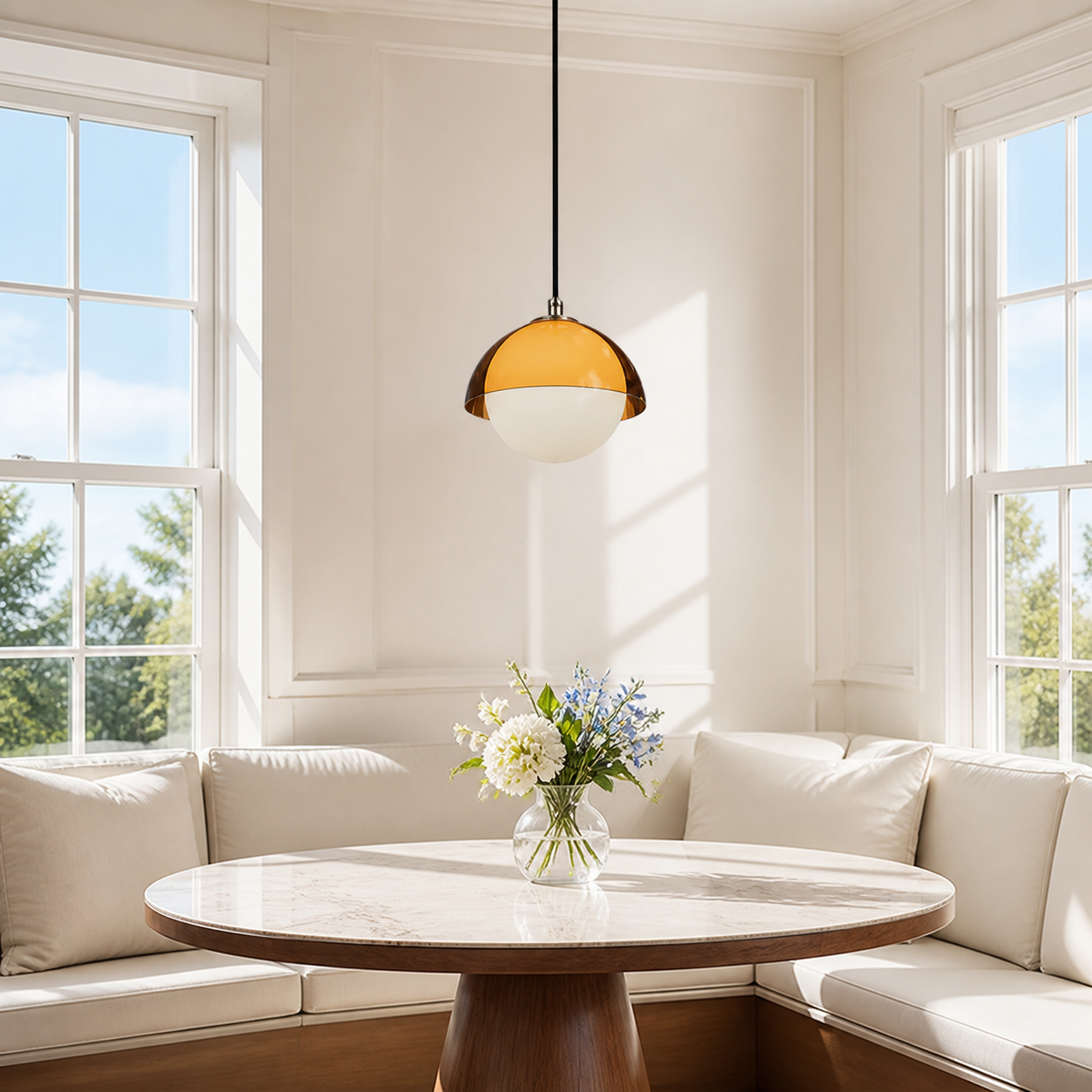 Walnut acrylic pendant above a bright breakfast banquette table