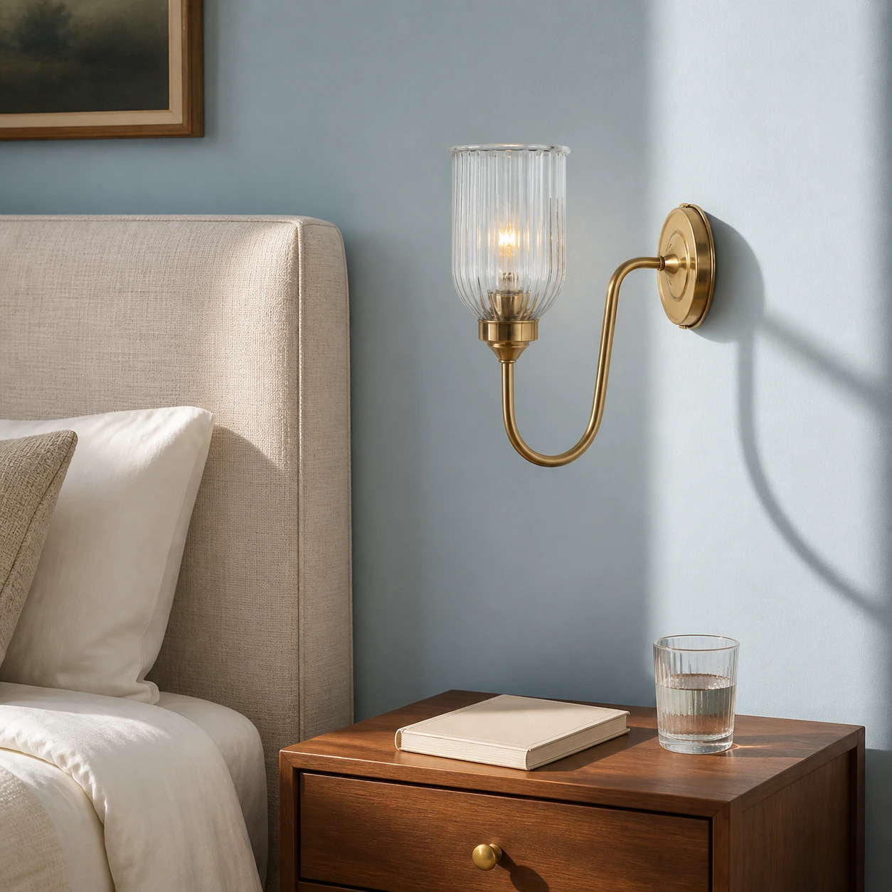 Menae Antique Brass wall sconce beside an upholstered bed