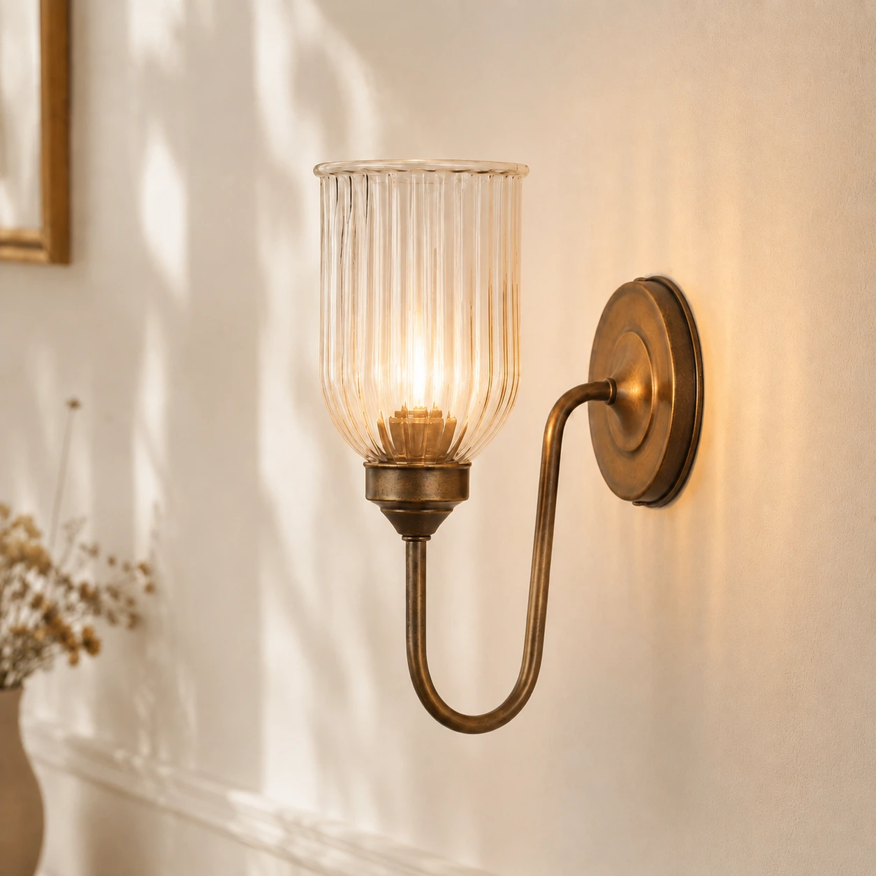 Menae Antique Brass ribbed glass wall sconce with warm glow